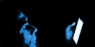 La luce blu e una persona che osserva un monitor al buio